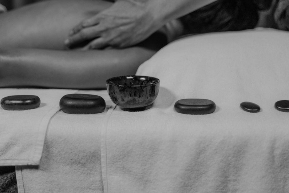 Relaxing spa scene with massage and hot stones for wellness and therapy.